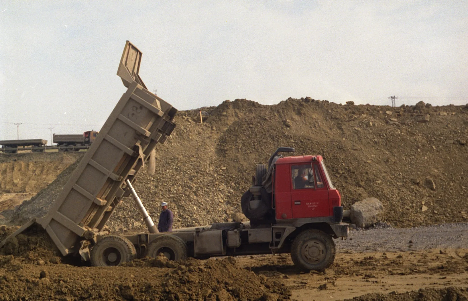 A tipper truck unloading soil at a working face.